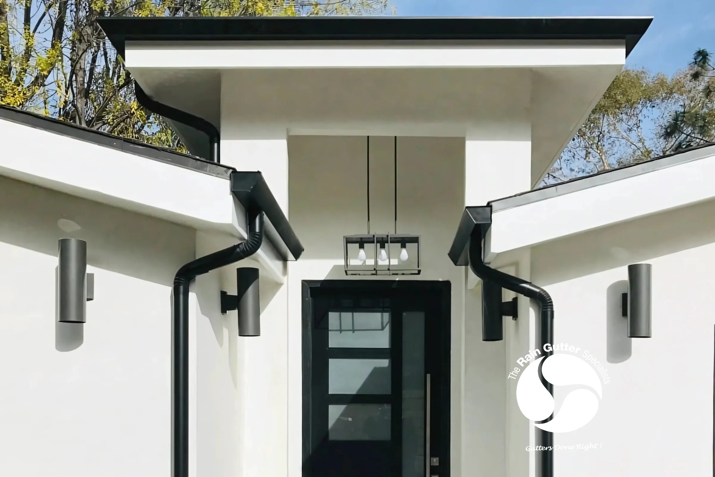 Dual black downspouts on white modern home
