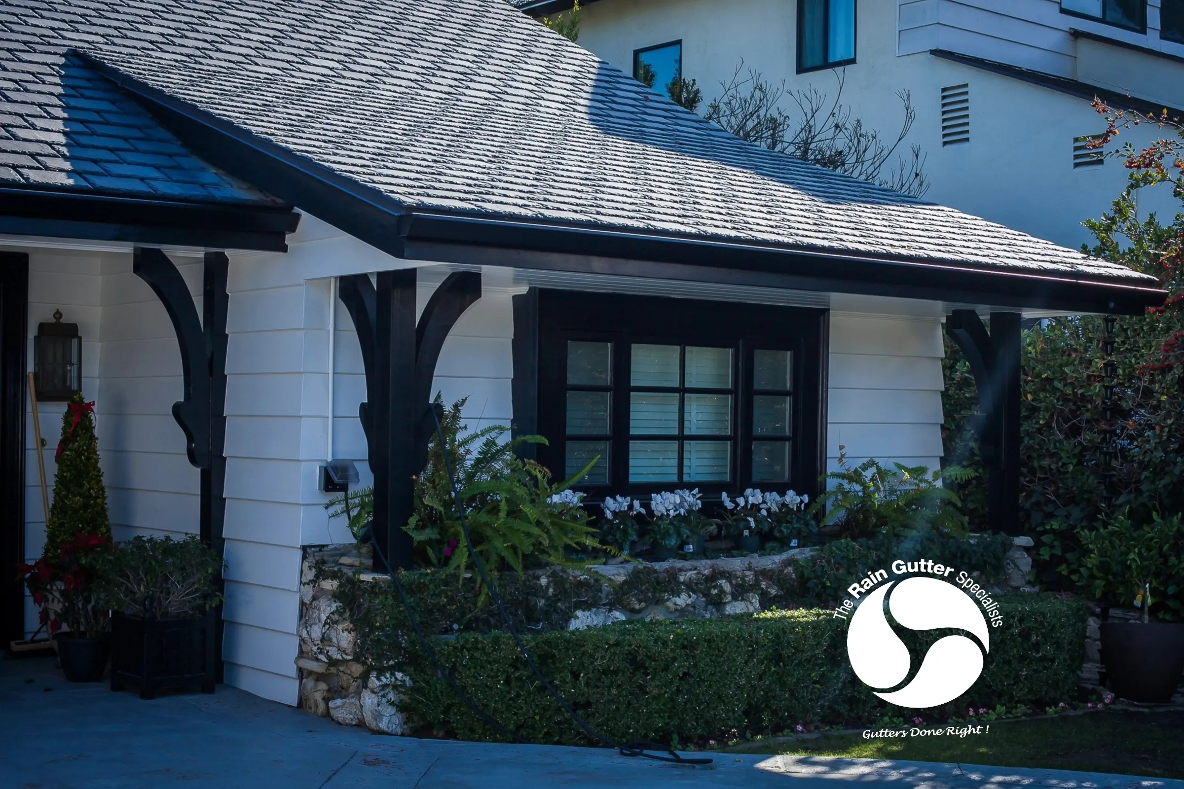 Front landscaping with black seamless gutters