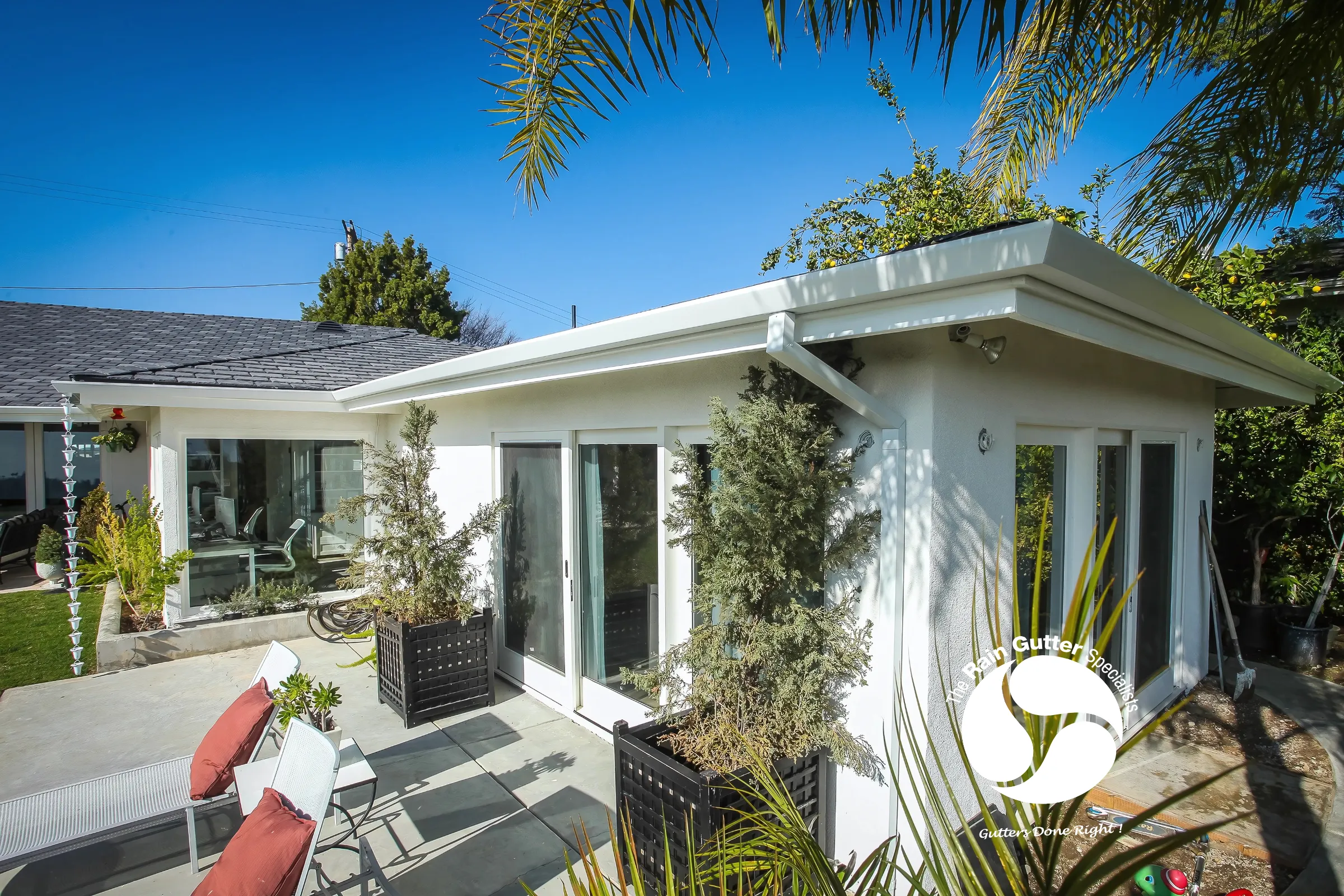 Lawn and modern house with white rain chain